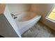 Bathroom featuring a built-in tub with tile surround and a window for natural light at 6283 Lorraine Ln, Spring Hill, FL 34608