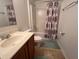 Bathroom with a vanity, toilet, and shower with a stylish curtain, creating a functional and well-organized space at 6283 Lorraine Ln, Spring Hill, FL 34608