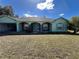 Inviting home featuring a well-manicured lawn, stone accents, arched entryways, and attached garage at 6283 Lorraine Ln, Spring Hill, FL 34608