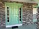 Close-up of the home's entryway, highlighting the stone accents, sidelights, and green front door at 6283 Lorraine Ln, Spring Hill, FL 34608