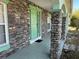 Inviting front entrance with stone columns and a stylish, bright green front door at 6283 Lorraine Ln, Spring Hill, FL 34608