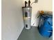 Water heater in the garage with nearby supplies and some nearby equipment such as a trashcan at 6283 Lorraine Ln, Spring Hill, FL 34608