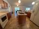 Open kitchen features a center island with a sink, tiled floor, and white appliances at 6283 Lorraine Ln, Spring Hill, FL 34608