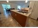 Kitchen featuring a center island, wood cabinets, tiled floors and a view of the dining area at 6283 Lorraine Ln, Spring Hill, FL 34608