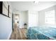 Bright bedroom with a colorful bedspread, closet, light hardwood floors, and a view of the home's hallway at 6906 N Central Ave, Tampa, FL 33604