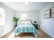 Bright bedroom features two windows, wood-look floors, and modern artwork at 6906 N Central Ave, Tampa, FL 33604
