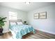 This bedroom features light hardwood floors, picture frames, and a comfortable bed with a colorful bedspread at 6906 N Central Ave, Tampa, FL 33604