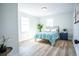 Bright bedroom features two windows, wood-look floors, and modern furnishings at 6906 N Central Ave, Tampa, FL 33604