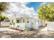 Charming cottage-style home with a inviting porch, green door, and lush landscaping at 6906 N Central Ave, Tampa, FL 33604