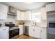 Bright, updated kitchen with stainless steel appliances, white cabinets, and a modern faucet at 6906 N Central Ave, Tampa, FL 33604