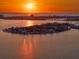 Aerial view of an island residential area at sunset, showcasing waterfront homes at 6976 S Shore S Dr, St Petersburg, FL 33707