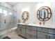 Well-lit bathroom with double vanity, quartz counters, decorative mirrors, glass-enclosed shower with marble-look tile at 6976 S Shore S Dr, St Petersburg, FL 33707