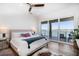 A bedroom with a ceiling fan, wooden floors, access to the deck and a beautiful water view at 6976 S Shore S Dr, St Petersburg, FL 33707