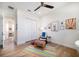 Inviting bedroom showcases hardwood floors, ceiling fan, and a cozy sitting area with artwork at 6976 S Shore S Dr, St Petersburg, FL 33707