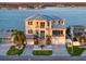 Waterfront home with a metal roof, featuring a multi-level exterior and an elegant stairway to the front door at 6976 S Shore S Dr, St Petersburg, FL 33707