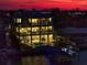 Waterfront home at dusk with a private pool, dock, and spacious balconies offering stunning waterfront views at 6976 S Shore S Dr, St Petersburg, FL 33707