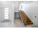 Bright foyer featuring a staircase with wood treads and a stylish metal railing at 6976 S Shore S Dr, St Petersburg, FL 33707