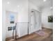 Bright hallway with wood floors leads to double doors and features a modern metal railing and a view from the window at 6976 S Shore S Dr, St Petersburg, FL 33707
