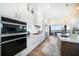 Bright kitchen featuring an island, stainless steel appliances, sleek white cabinetry, and hardwood floors with water views at 6976 S Shore S Dr, St Petersburg, FL 33707