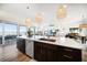 Spacious kitchen island with seating, modern lighting, and open floor plan to the living area with water views at 6976 S Shore S Dr, St Petersburg, FL 33707