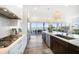 Modern kitchen with stainless appliances, stone countertops, and large windows with beautiful waterfront views at 6976 S Shore S Dr, St Petersburg, FL 33707