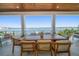 Waterfront patio with a large wooden table, seating for eight, and stunning water views at 6976 S Shore S Dr, St Petersburg, FL 33707