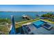 Backyard featuring a pool, boat dock, lounge chairs and serene water views at 6976 S Shore S Dr, St Petersburg, FL 33707