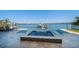 View of the backyard pool and spa with a boat dock and waterfront views at 6976 S Shore S Dr, St Petersburg, FL 33707