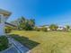View of the backyard showing the lawn, landscaping and the exterior of neighboring homes at 8622 140Th Way, Seminole, FL 33776