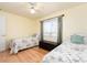 A well lit bedroom with two twin beds, a window, and a bench at 8622 140Th Way, Seminole, FL 33776