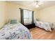 Guest bedroom featuring two twin beds with floral bedding and a center ottoman at 8622 140Th Way, Seminole, FL 33776