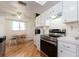 Well-lit kitchen with white cabinets and countertops, hardwood floors and modern stainless-steel range at 8622 140Th Way, Seminole, FL 33776