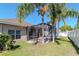 A screened-in lanai and manicured lawn with tropical trees is the highlight of the backyard at 9961 Jasmine Brook Cir, Land O Lakes, FL 34638