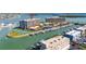 Aerial view of waterfront condo buildings with boat docks, tennis court, and parking at 1 Key Capri # 604W, Treasure Island, FL 33706