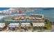 Aerial view showcasing waterfront condos, boat docks, pool, and tennis court near the bay at 1 Key Capri # 604W, Treasure Island, FL 33706