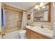 Cozy bathroom featuring a bathtub, shower, vanity with sink, and decorative elements at 1 Key Capri # 604W, Treasure Island, FL 33706