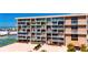 Exterior view of a multi-story condominium building with private balconies and marina views at 1 Key Capri # 604W, Treasure Island, FL 33706