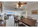 Spacious dining area open to the living room, showcasing a wooden table and chairs beneath a decorative ceiling fan at 1 Key Capri # 604W, Treasure Island, FL 33706