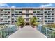 Condo building entrance with bridge access, landscaped planters, and prominent signage at 1 Key Capri # 604W, Treasure Island, FL 33706