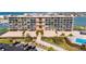 Condo exterior showcasing manicured landscaping, parking, a pool, and waterway access at 1 Key Capri # 604W, Treasure Island, FL 33706