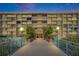Night view of condominium entrance with bridge access, landscaped planters and prominent signage at 1 Key Capri # 604W, Treasure Island, FL 33706
