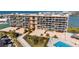 Exterior view of condominium complex with landscaping, pool, and bayside location at 1 Key Capri # 604W, Treasure Island, FL 33706