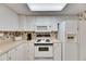 Traditional kitchen with white appliances, cabinets, and a patterned backsplash, offering a functional cooking space at 1 Key Capri # 604W, Treasure Island, FL 33706