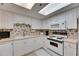 Bright kitchen with white cabinetry, laminate countertops, and modern appliances for comfortable cooking at 1 Key Capri # 604W, Treasure Island, FL 33706