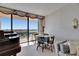 Inviting living room with a piano, dining table, and sliding doors offering panoramic views at 1 Key Capri # 604W, Treasure Island, FL 33706