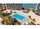 Aerial view of a sparkling blue pool with lounge chairs surrounded by lush landscaping at 1 Key Capri # 604W, Treasure Island, FL 33706