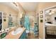 Well-appointed bathroom featuring a vanity with a large mirror, a tub, and bright turquoise cabinets at 10017 Courtney Palms Blvd # 301, Tampa, FL 33619
