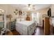 A cozy bedroom features hardwood floors, a ceiling fan, and a large window for natural light at 10017 Courtney Palms Blvd # 301, Tampa, FL 33619