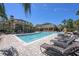 Stunning community pool with lounge chairs, landscaping, and a beautiful clubhouse at 10017 Courtney Palms Blvd # 301, Tampa, FL 33619