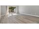 Light-filled bedroom with gray wood floors and a sliding glass door leading to a private balcony at 102 Old Mill Pond Rd, Palm Harbor, FL 34683